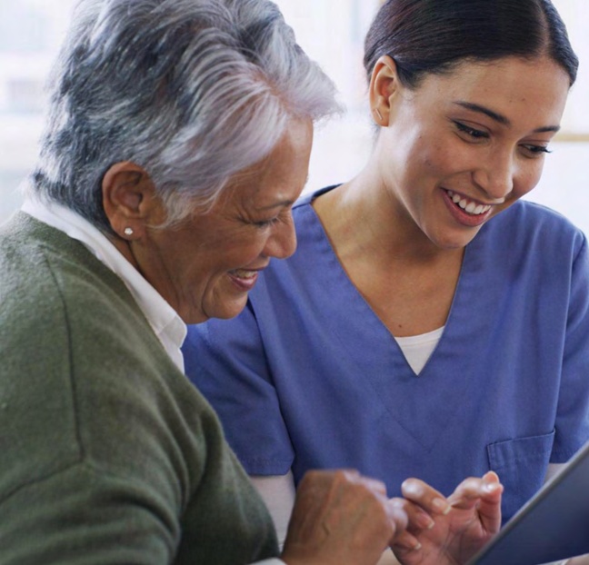 A nurse helping an older patient feel connected and cared for